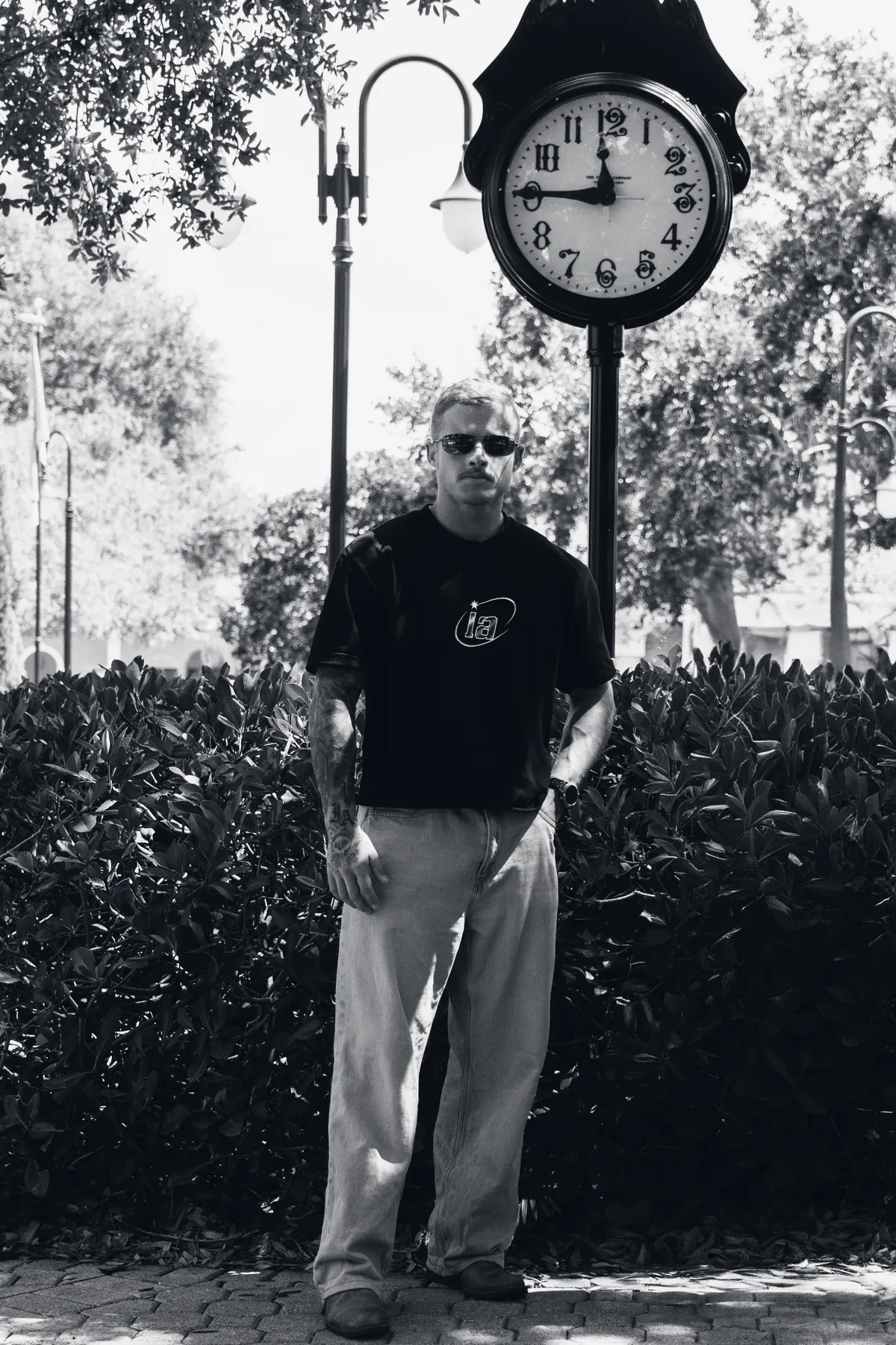 Athlete in the black ia tee beside a street clock